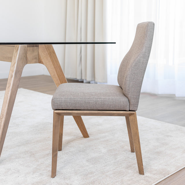 Chaise de cuisine en tissu beige avec pieds en bois naturel dans un intérieur moderne.