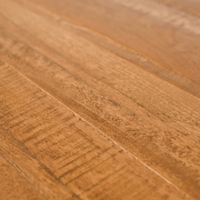 image rapprochée d'une table a manger en bois massif avec pieds metalliques noirs et chaises blanches modernes dans salle lumineuse.