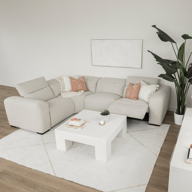 table basse blanche moderne en bois dans un salon minimaliste avec canape beige et decor epure.