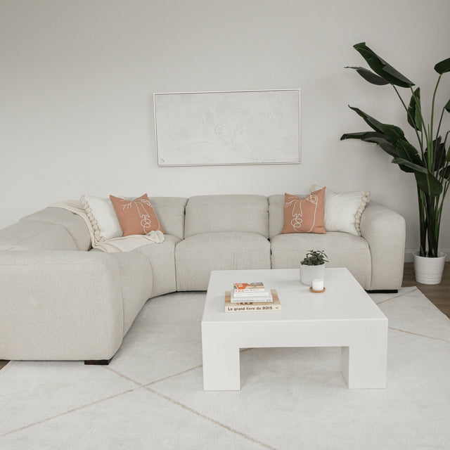 table basse blanche moderne en bois dans un salon minimaliste avec canape beige et decor epure.