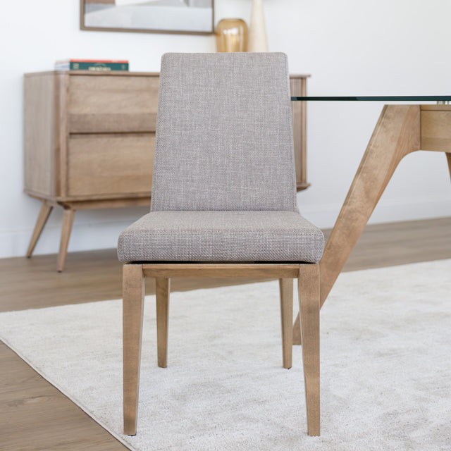 Chaise de cuisine en tissu beige avec structure en bois naturel près d’une table contemporaine.