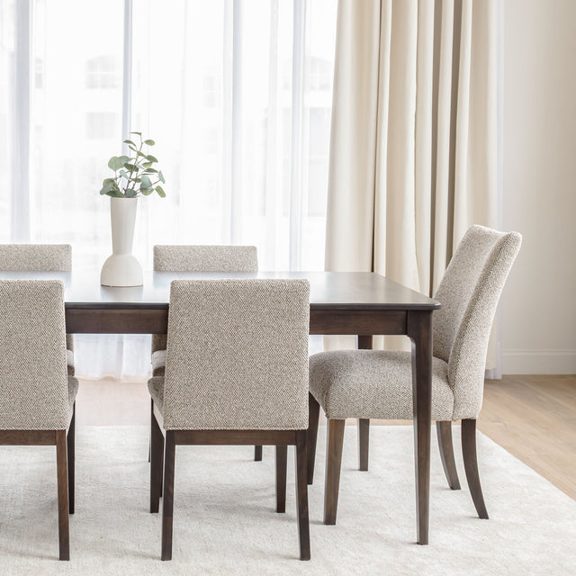 Chaise de salle à manger rembourrée en tissu beige avec pattes en bois foncé, style contemporain et confortable.