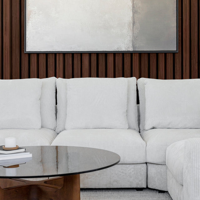 Modulaire d angle en tissu corduroy creme avec table basse en bois et decor minimaliste sur tapis clair.