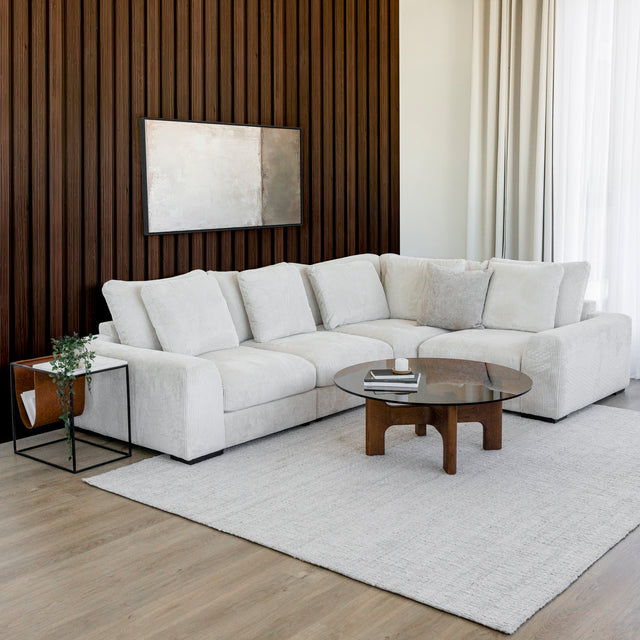 Modulaire d angle en tissu corduroy creme avec table basse en bois et decor minimaliste sur tapis clair.