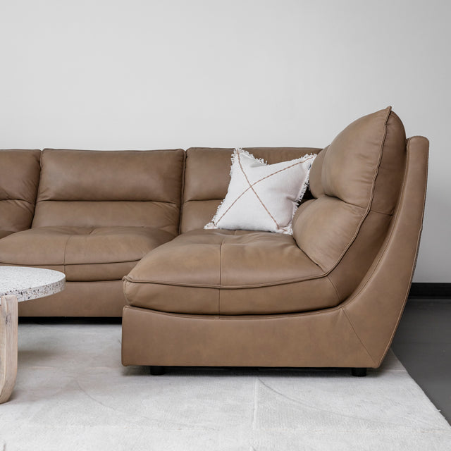 angle de canape en cuir brun clair avec coussin decoratif blanc.