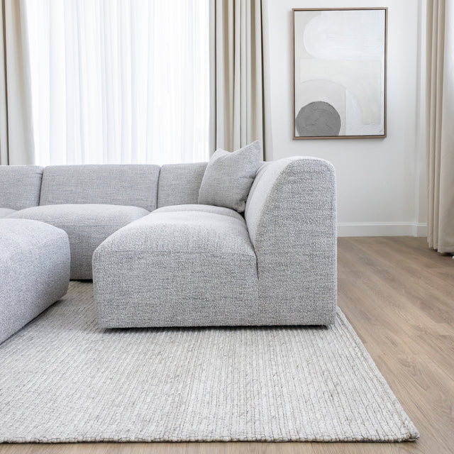 canape d angle gris clair en tissu boucle dans salon moderne et lumineux.