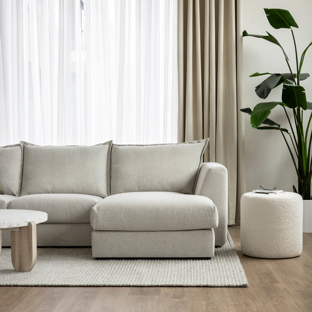 canape beige clair avec meridienne dans salon epure sur tapis creme.