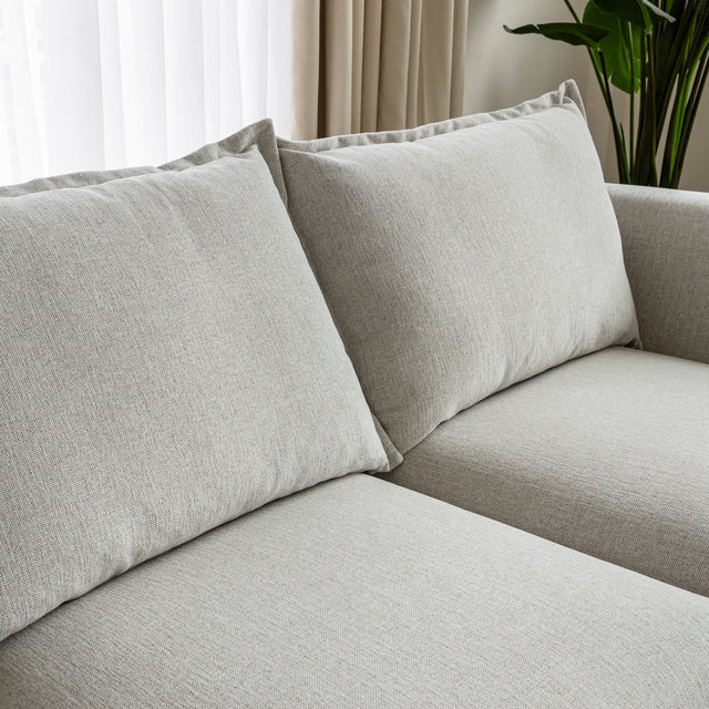 gros plan sur coussins de dossier et assise de canape beige clair en tissu texture.