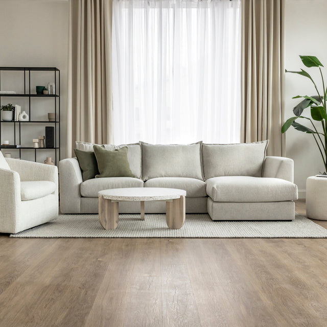 canape beige clair avec coussins verts dans salon moderne et lumineux.