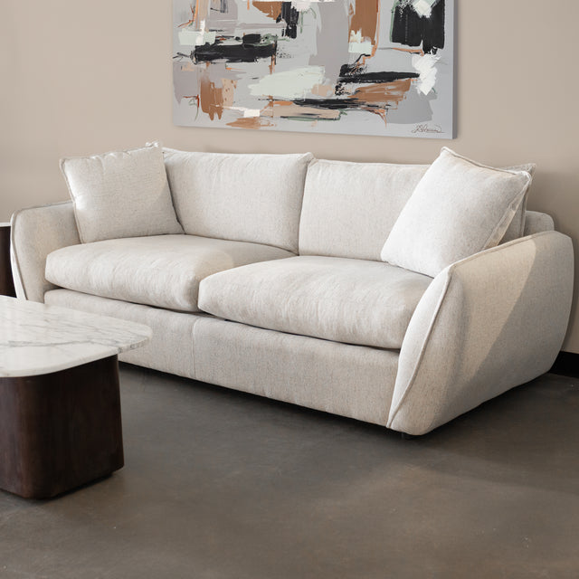 canape beige clair avec coussins moelleux et table basse en marbre dans salon contemporain.