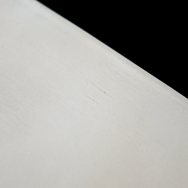 Table à manger moderne avec plateau béton ciment, tranche de frêne noir et piètement en métal noir, idéale pour salle à manger contemporaine.