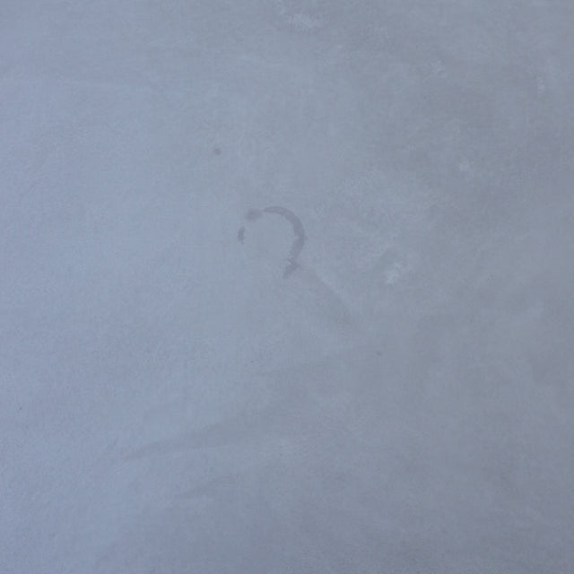 Table de salle à manger au design rectangulaire, plateau clair et piétement en X noirs, dans une salle à manger lumineuse.