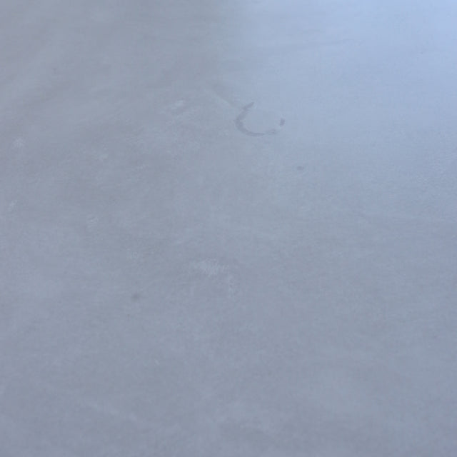Table de salle à manger au design rectangulaire, plateau clair et piétement en X noirs, dans une salle à manger lumineuse.