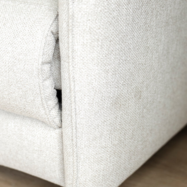 Image rapprochée d'un Sectionnel en tissu greige avec pattes noires, design moderne et assises confortables pour salon contemporain.