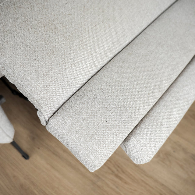 Image rapprochée d'un Sectionnel en tissu greige avec pattes noires, design moderne et assises confortables pour salon contemporain.