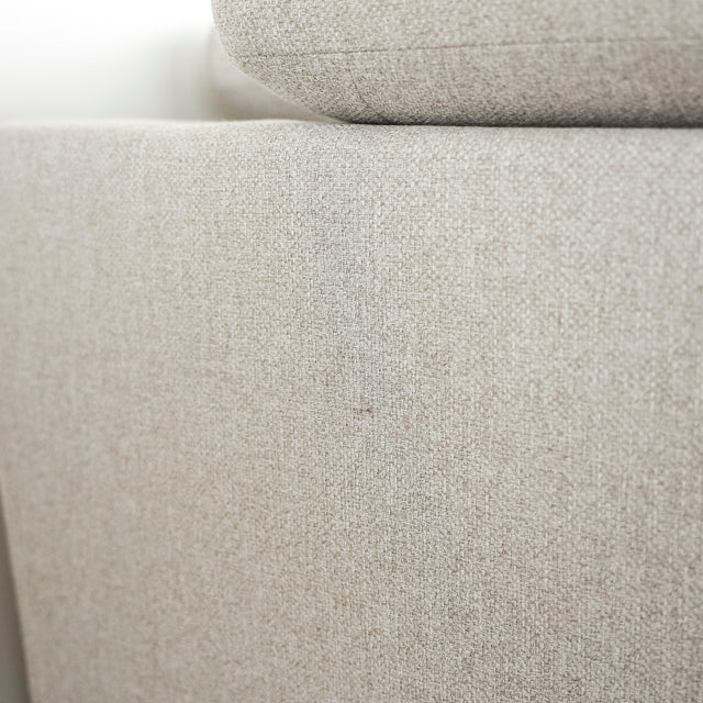 Image rapprochée d'un Sectionnel en tissu greige avec pattes noires, design moderne et assises confortables pour salon contemporain.