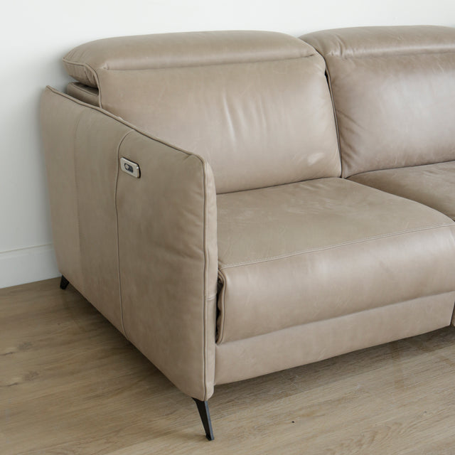 detail du canape en cuir beige avec accoudoir et bouton de commande metalique.