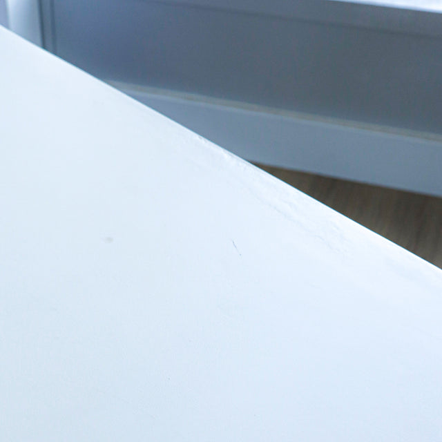 gros plan du plateau de table blanc mat montrant une texture lisse avec de legeres marques de surface.