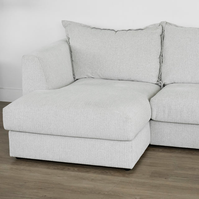 module de canape gris clair avec assise large et coussins moelleux sur sol en bois.