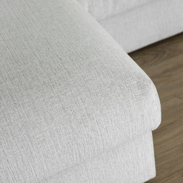 gros plan sur coin d assise de canape gris clair en tissu texture fine.