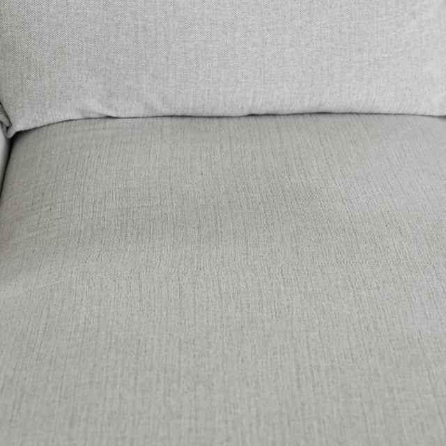 gros plan sur assise de canape gris clair en tissu texture douce.