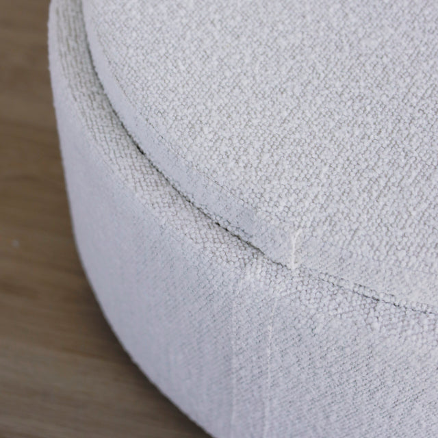 image rapprochée d'un ottoman en tissu blanc bouclé avec plateau amovible en bois noyer.