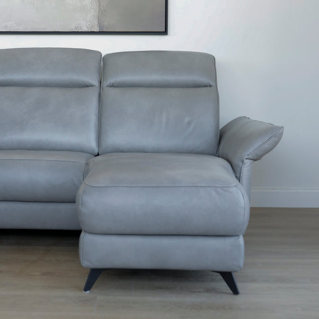 Canape avec chaise longue droite en cuir gris clair avec pieds noirs.