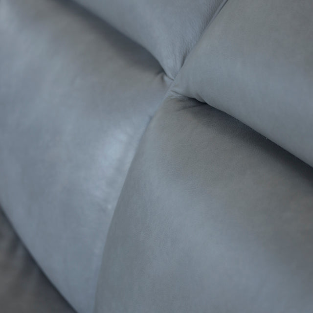 Image rapprochée d'un Canape avec chaise longue droite en cuir gris clair avec pieds noirs.