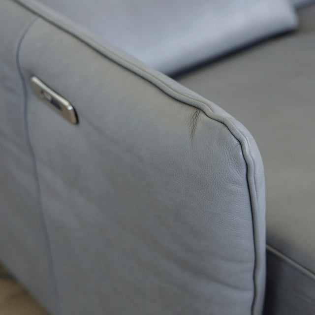 Image rapprochée d'un Canape avec chaise longue droite en cuir gris clair avec pieds noirs.