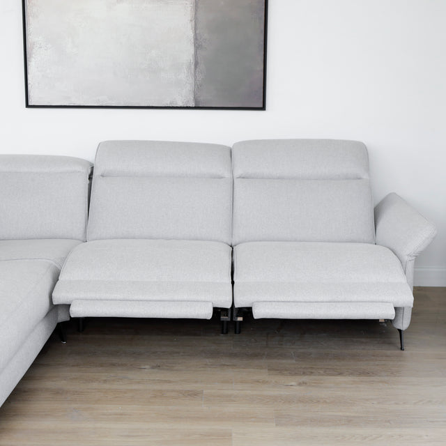 Modulaire inclinable moderne en tissu gris clair avec pieds metalliques noirs sur parquet clair.