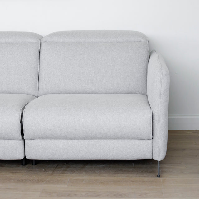 Modulaire inclinable moderne en tissu gris clair avec pieds metalliques noirs sur parquet clair.