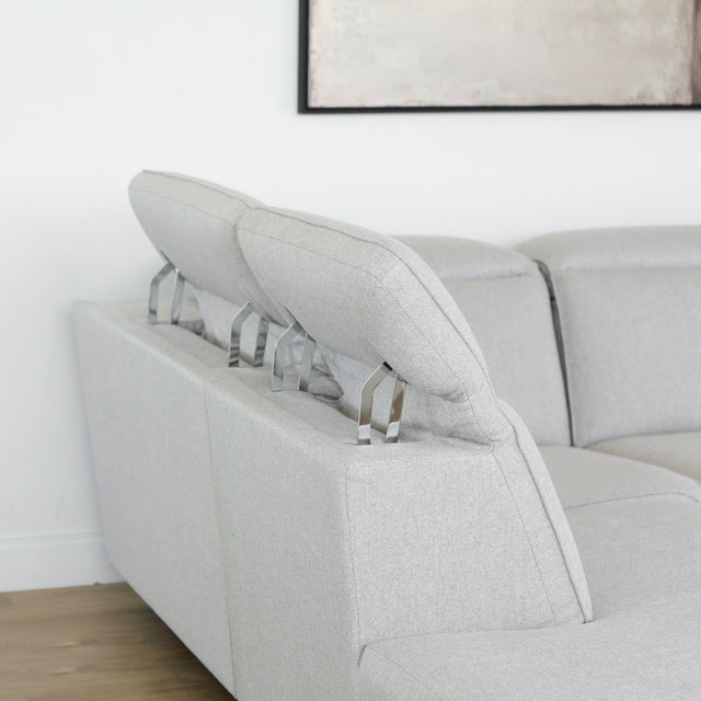 Modulaire inclinable moderne en tissu gris clair avec pieds metalliques noirs sur parquet clair.