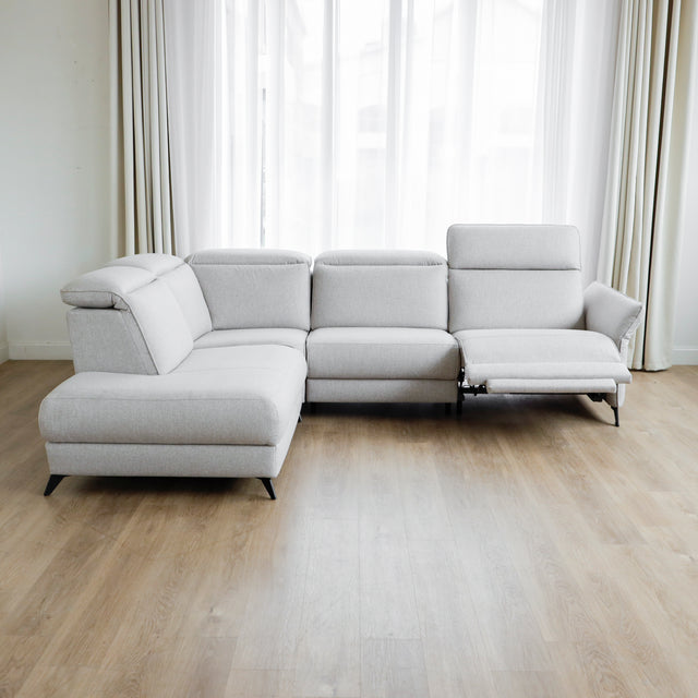 Modulaire inclinable moderne en tissu gris clair avec pieds metalliques noirs sur parquet clair.