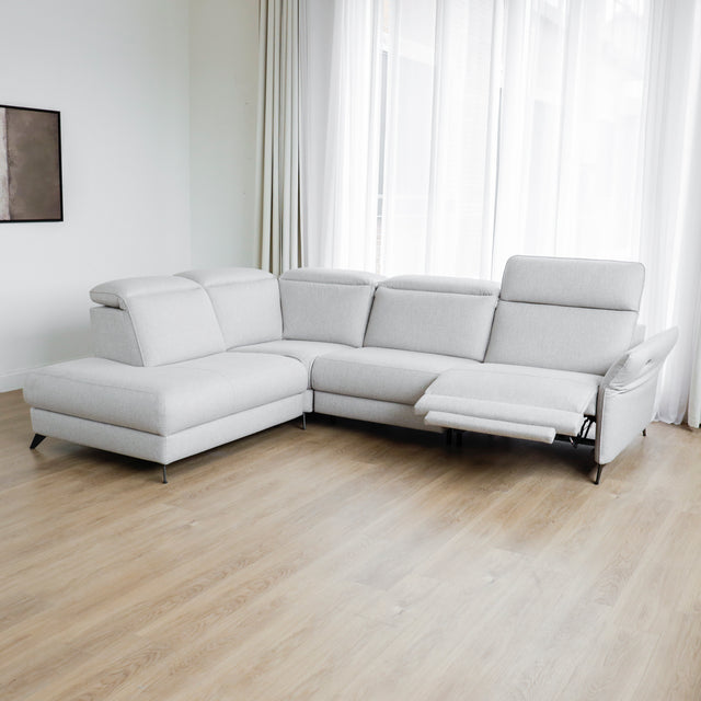 Modulaire inclinable moderne en tissu gris clair avec pieds metalliques noirs sur parquet clair.