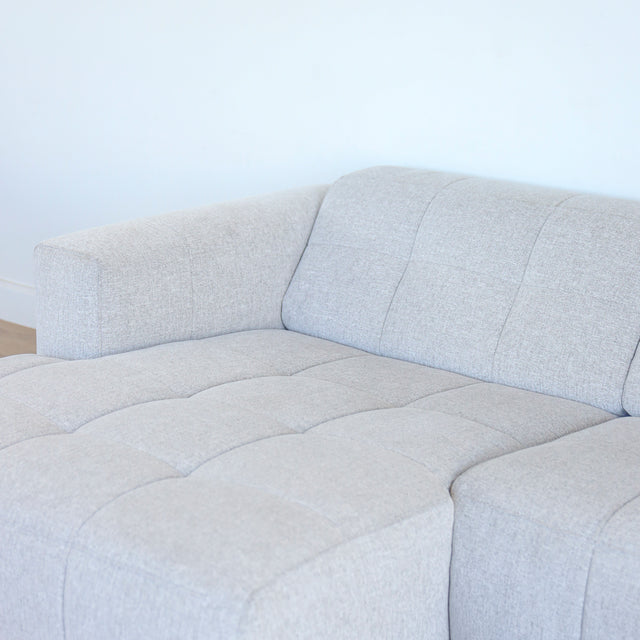 Imagee rapprochée d'un Modulaire d'angle moderne avc chaise longue gauche en tissu gris clair.