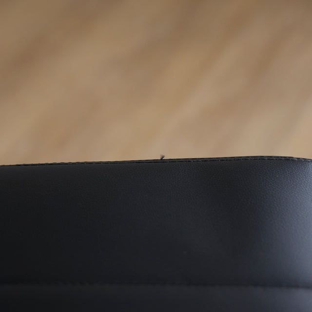 Image rapprochée de Quatre chaises noires en simili cuir avec pieds en metal, design moderne pour salle a manger.