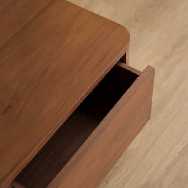 Table de chevet moderne en bois noyer avec coins arrondis et tiroir integre.