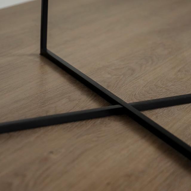 Image rapprochée des pattes d'une Table basse ronde avec plateau en marbre blanc et structure en metal noir, style moderne et minimaliste.