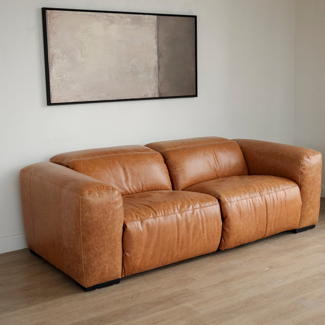 Canape en cuir brandy au design contemporain avec accoudoirs larges et assises confortables.