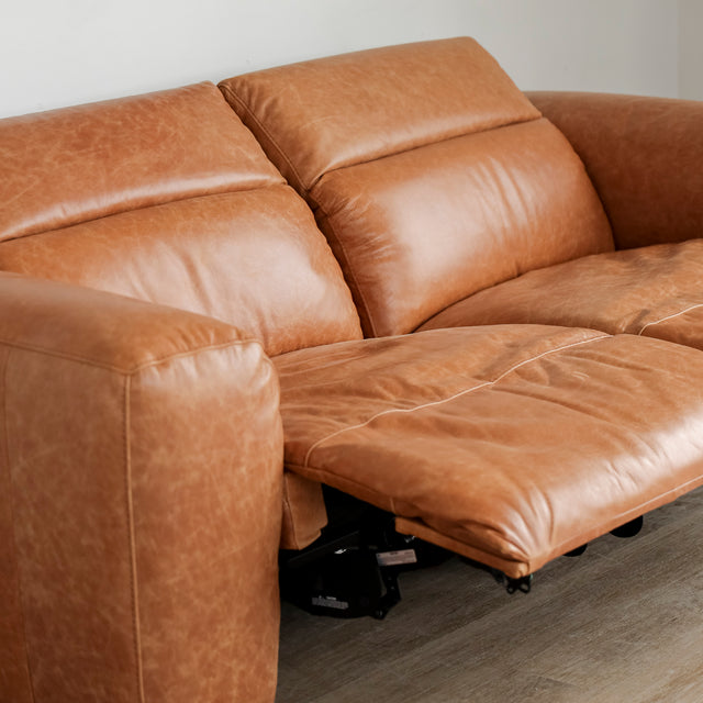 Canape inclinable en cuir brandy au design contemporain avec accoudoirs larges et assises confortables.