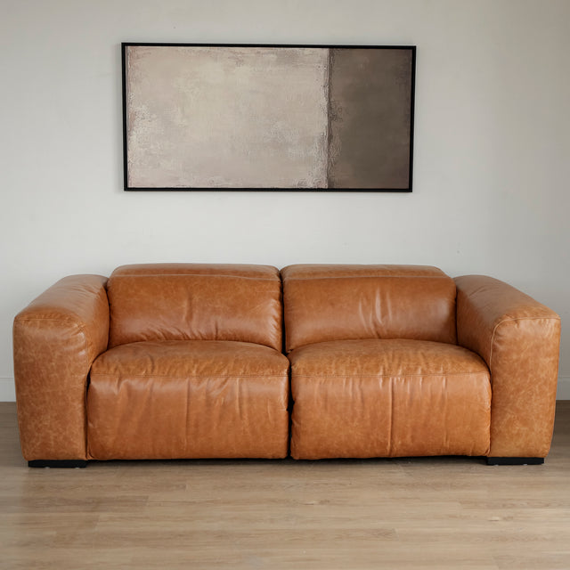 Canape inclinable en cuir brandy au design contemporain avec accoudoirs larges et assises confortables.