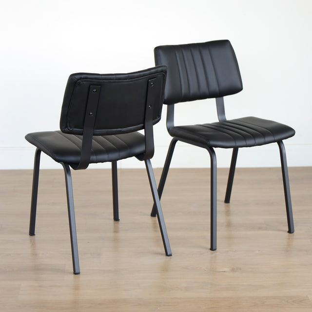 Deux chaises noires en simili cuir avec structure en metal, design industriel moderne.