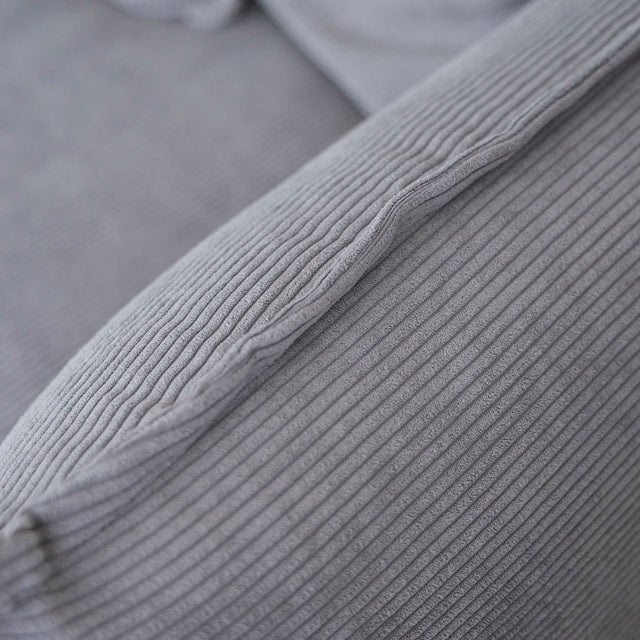 Image rapprochée d'un canapé gris moderne avec coussins moelleux dans un salon minimaliste.