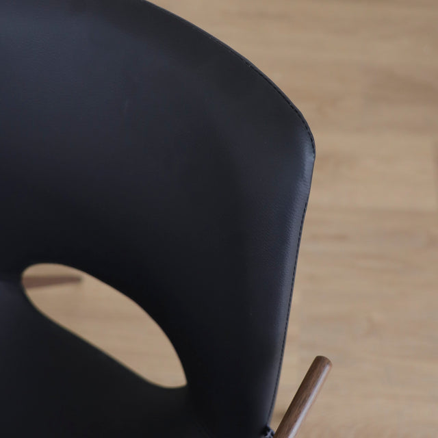 ensemble de chaises noires modernes avec accoudoirs en métal imitation bois et assise ajouree.