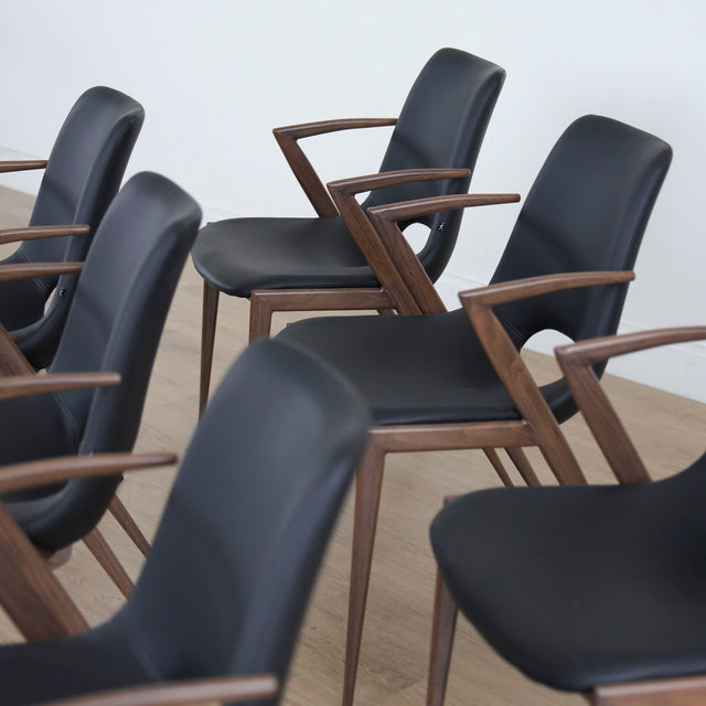 ensemble de chaises noires modernes avec accoudoirs en métal imitation bois et assise ajouree.