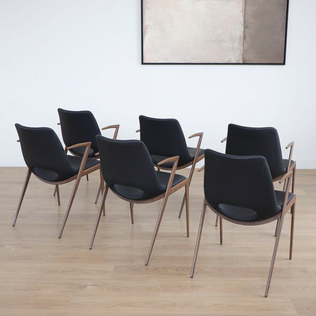 ensemble de chaises noires modernes avec accoudoirs en métal imitation bois et assise ajouree.