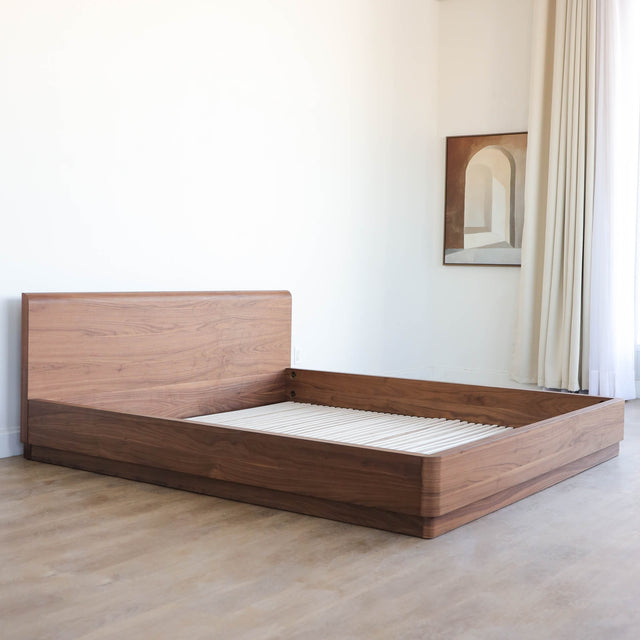 Lit en bois massif noyer avec tête de lit pleine, design minimaliste pour chambre moderne.