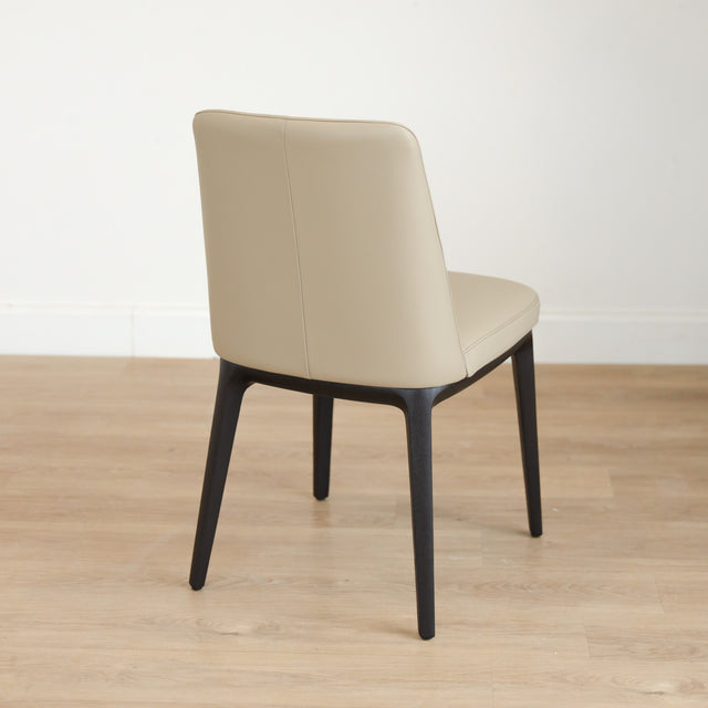 Chaise de salle à manger en cuir taupe avec pattes en noyer, design moderne pour intérieur contemporain.