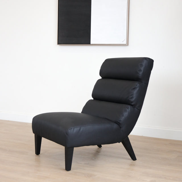 Fauteuil en cuir végane noir avec dossier matelassé et pieds inclinés, style moderne pour salon.