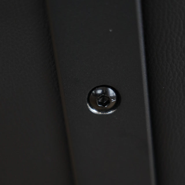 Deux chaises de salle à manger en cuir végane noir, piètement en métal, design moderne, présentées dans un intérieur minimaliste.